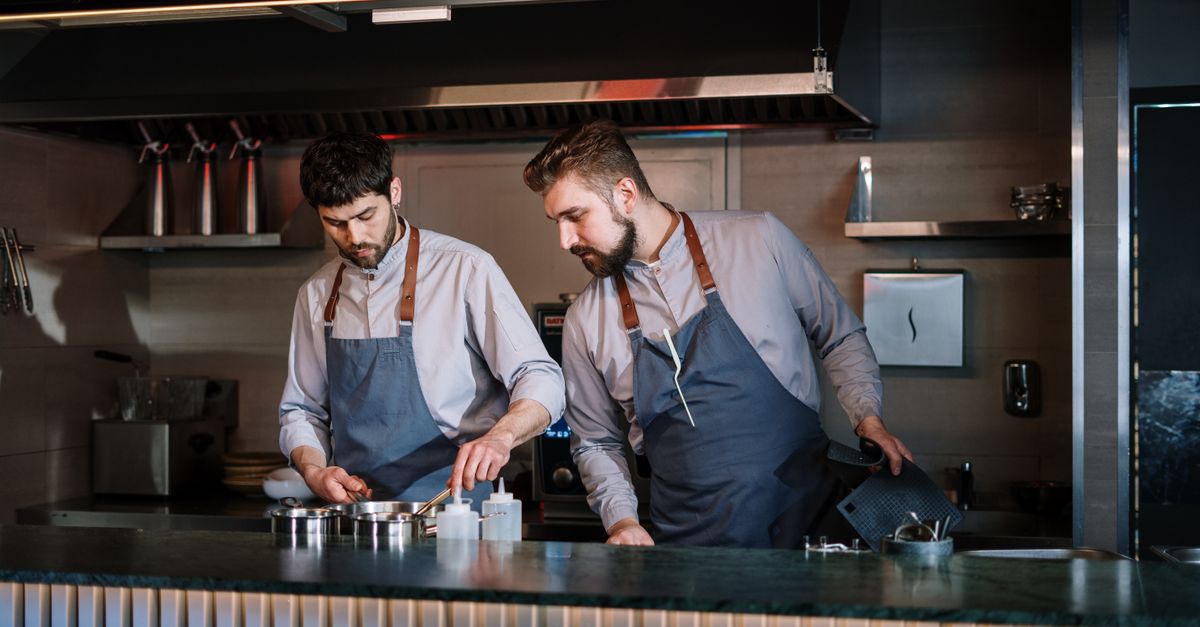 A caterer plating dishes in a busy kitchen ahead of a weekend event