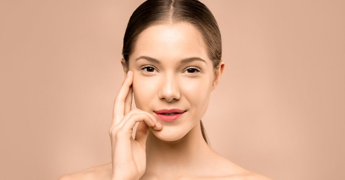 A patient with clear, healthy skin smiling after seeing a dermatologist
