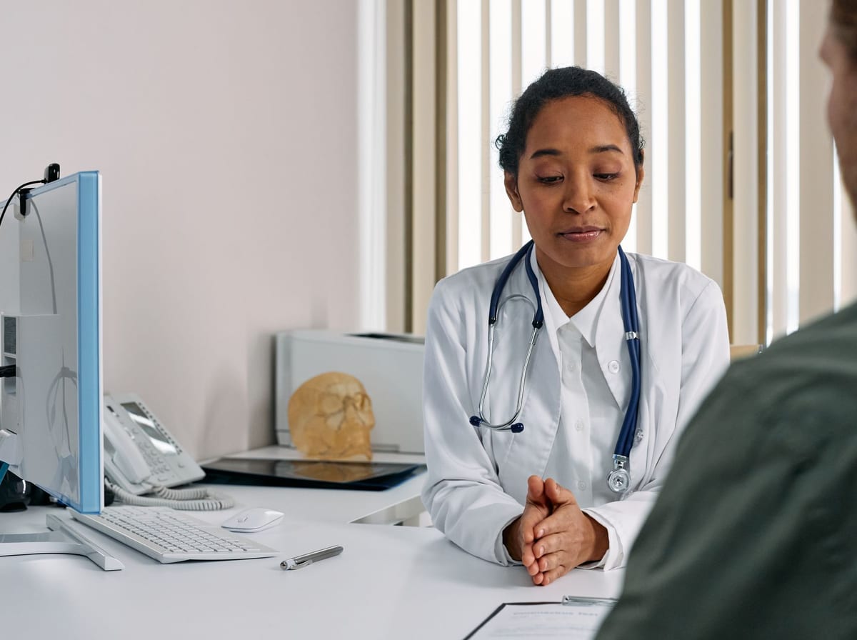 A doctor consulting a new patient across the desk in a bright, welcoming medical office