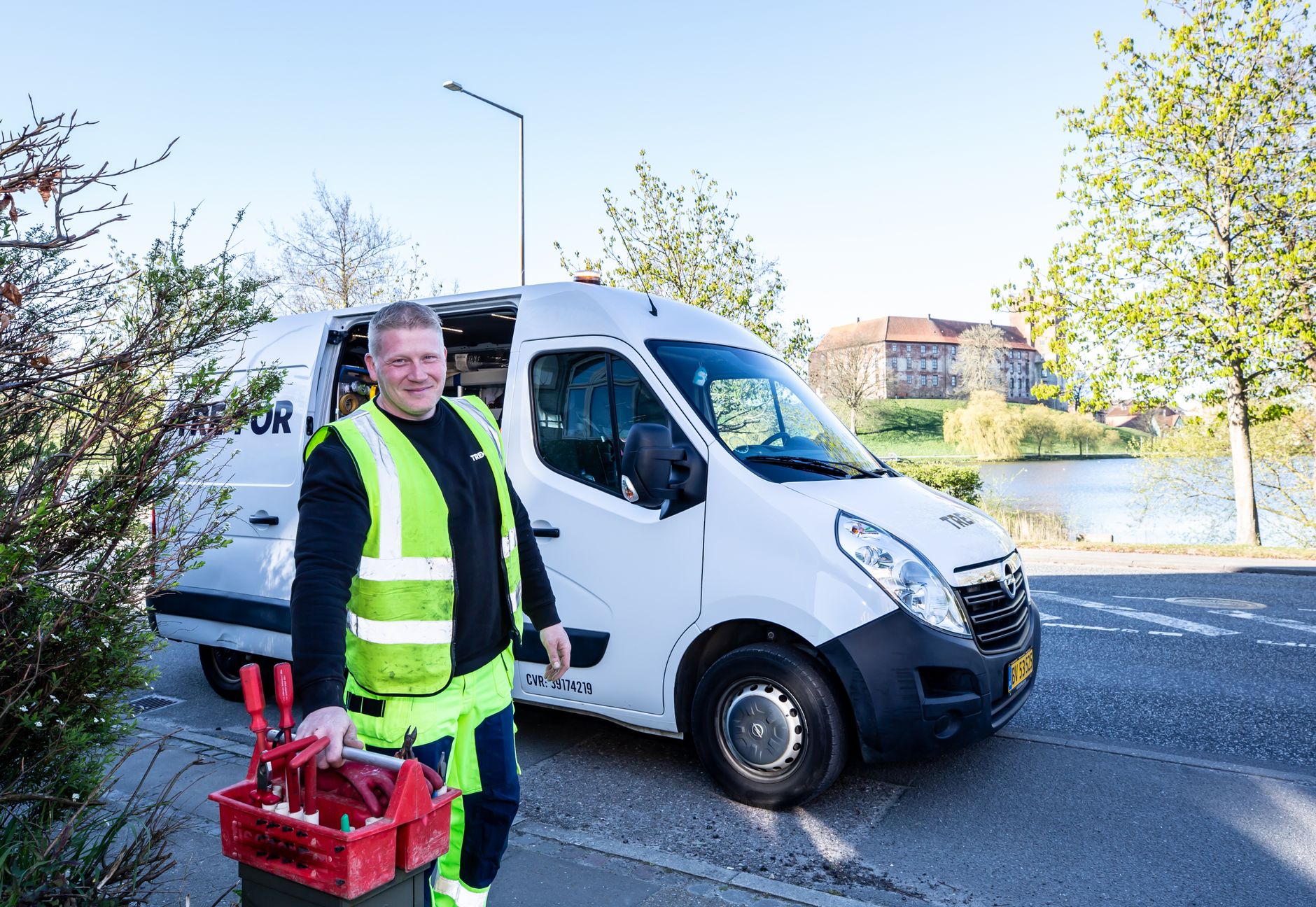 An electrician with tools beside the service van
