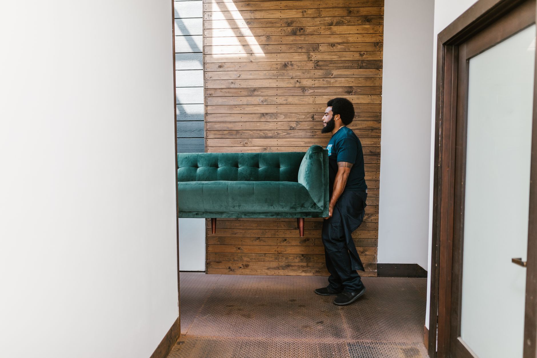 A professional mover carrying a sofa during a home move
