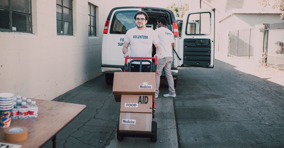 Nonprofit volunteers loading boxes of food and medicine aid to deliver to the community