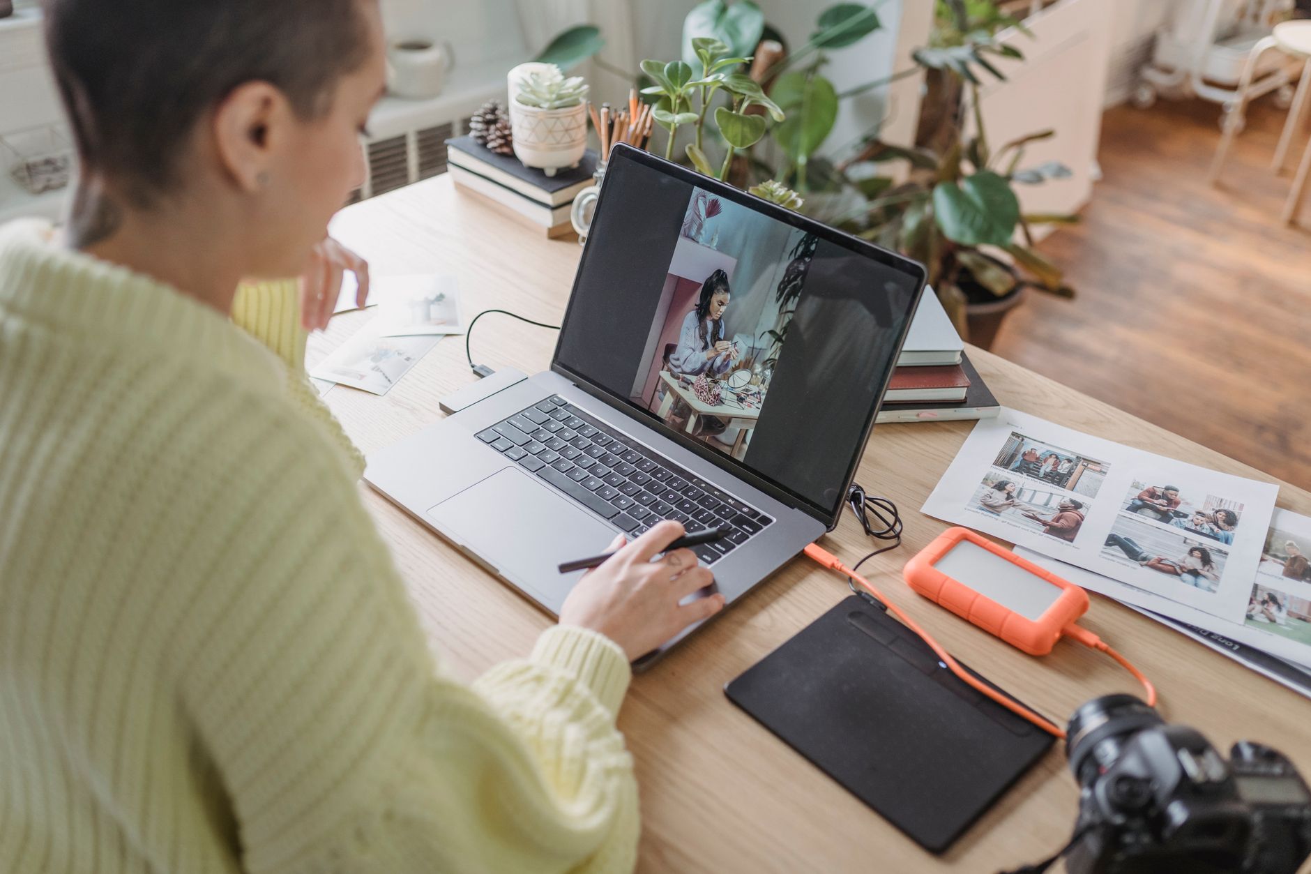 A photographer editing a gallery of photos on a laptop
