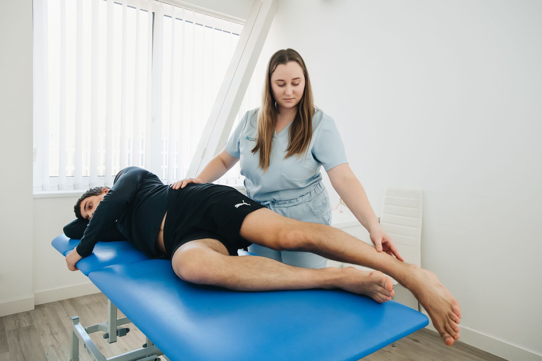 A physical therapist working hands on with a patient in a session