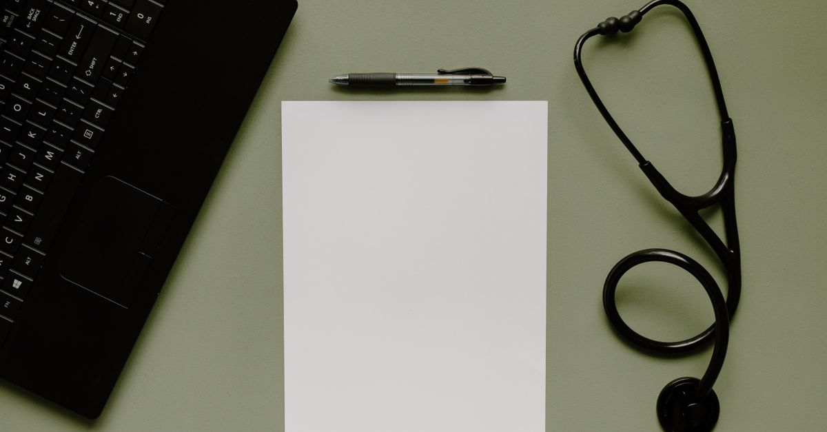 A podiatrist charting notes on a laptop between back to back patient visits