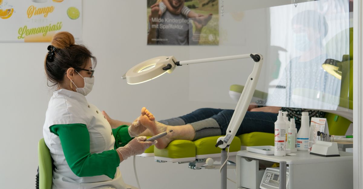 A friendly podiatrist examining a patient's foot in a bright modern exam room