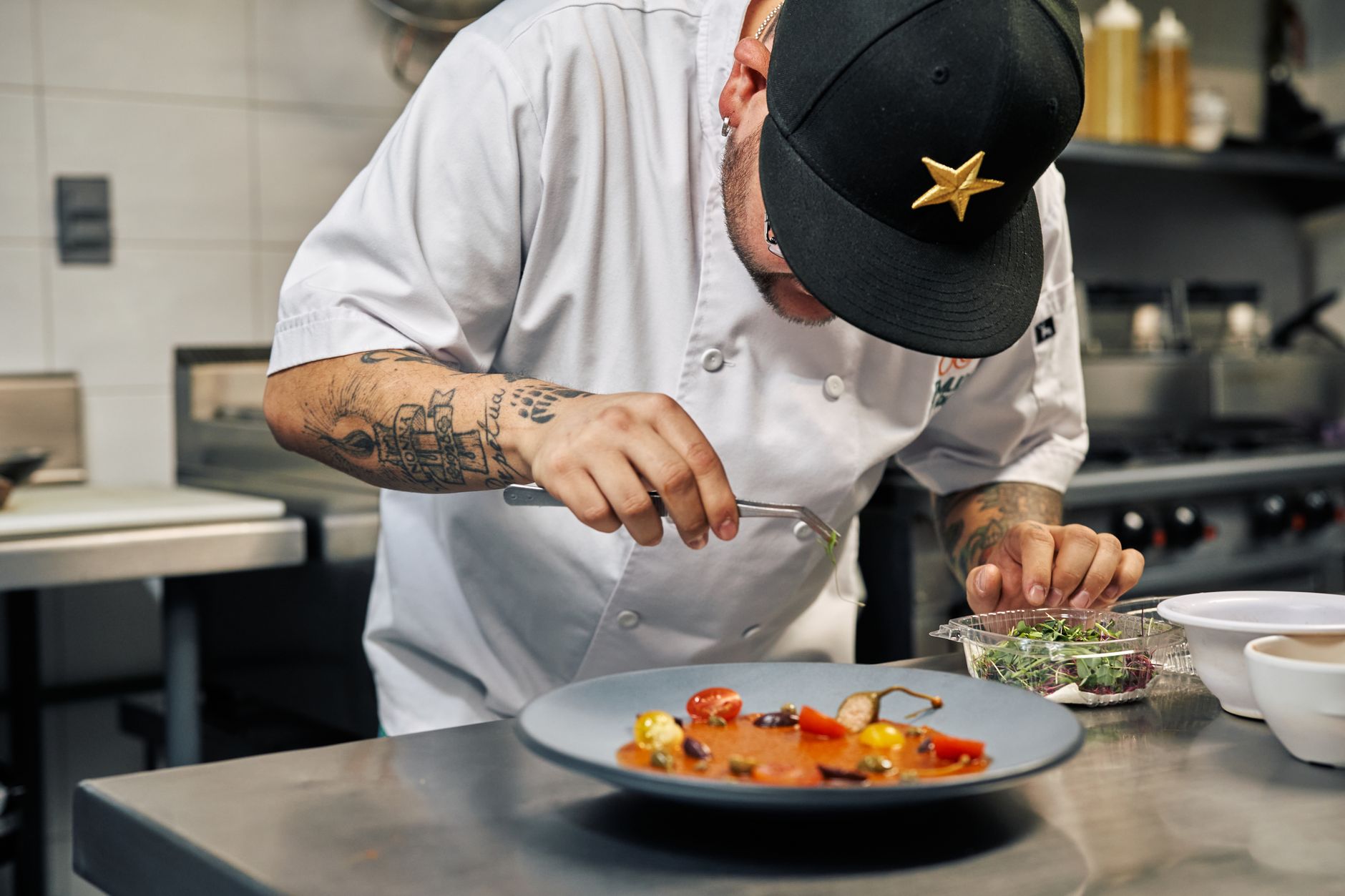 A chef plating a dish in a busy restaurant kitchen