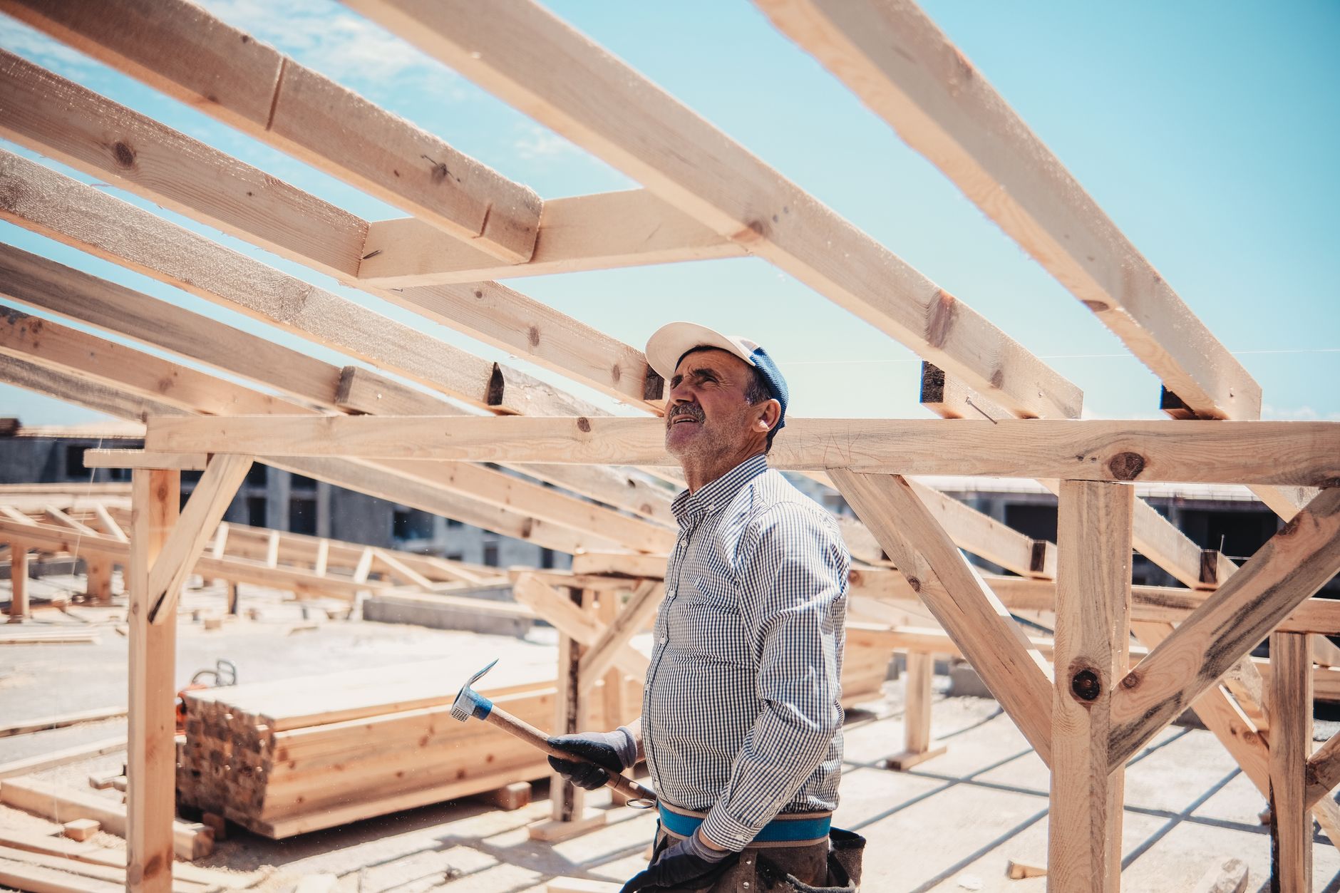 A roofer working on a roof frame on a sunny day