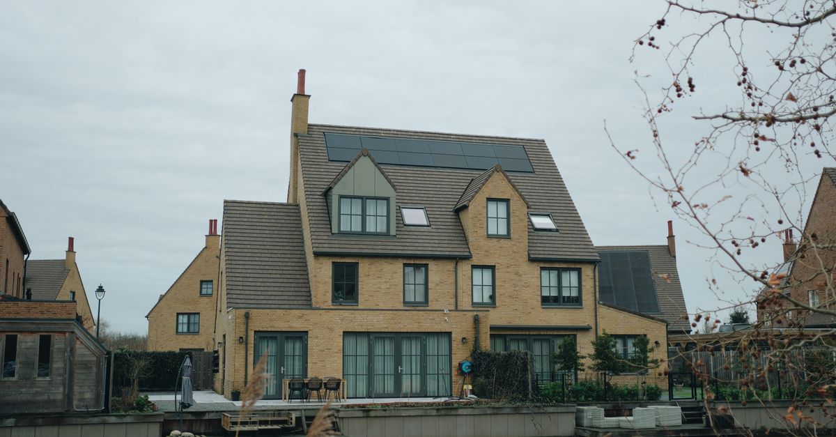 A homeowner reviewing a solar proposal at their kitchen table with a finished rooftop array visible outside