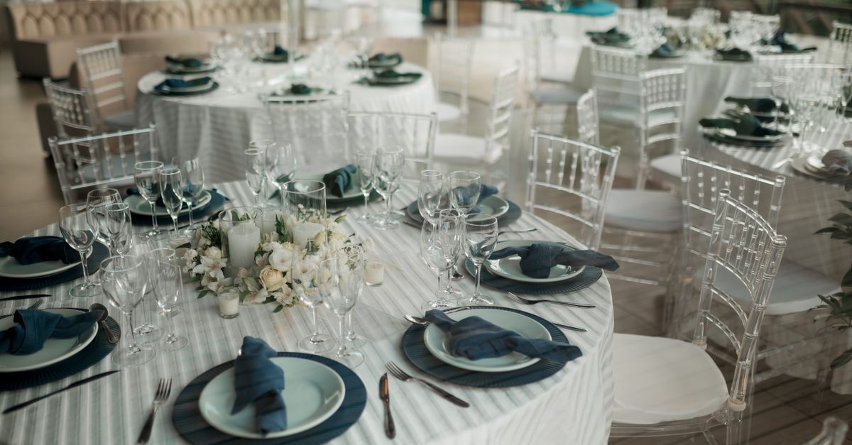 A wedding planner reviewing a seating chart and florals at a reception venue